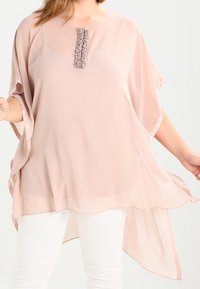Ljusrosa blus av genomskinligt tyg med lös passform, med rundad halsringning och dekoration längs mitten fram.