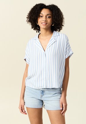 Camicia a maniche corte a righe blu e bianche con colletto, abbinata a pantaloni corti in denim chiaro. Tessuto morbido, design casual.