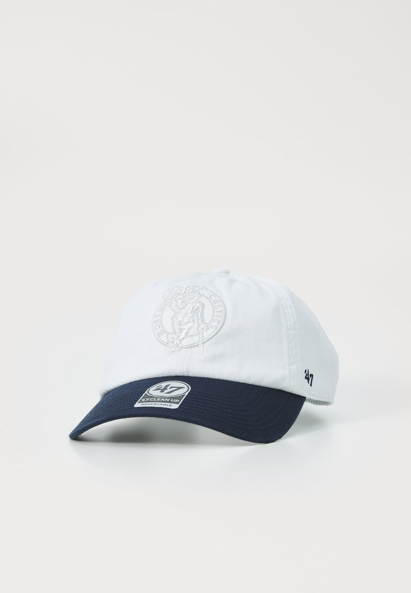 White cotton baseball cap with a navy blue brim, featuring an embroidered logo on the front and a branded label on the side.