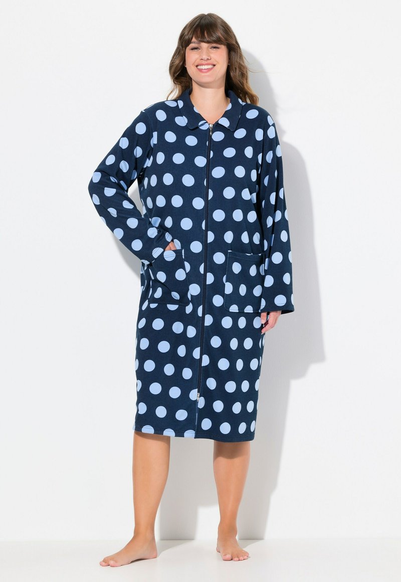 Accappatoio navy con pois, circoli azzurri, maniche lunghe, colletto, zip frontale e due tasche anteriori. Tessuto morbido.