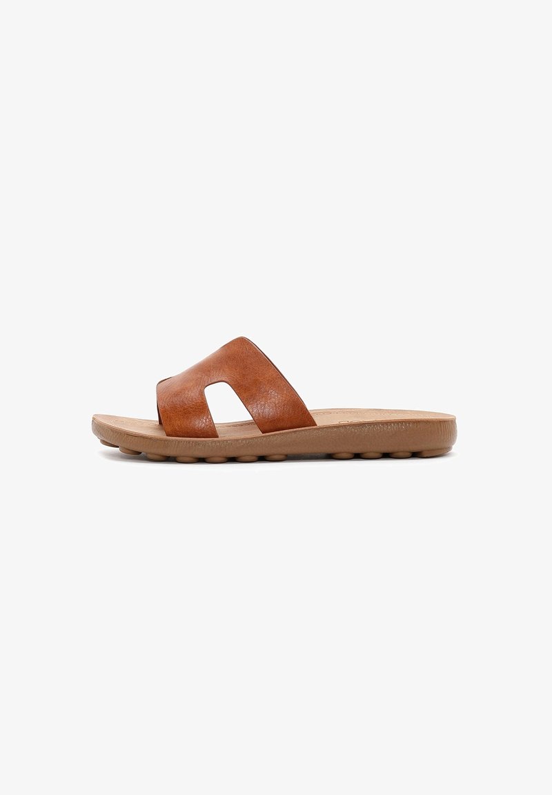 Sandale mule en cuir marron avec une large bride et une semelle rembourrée présentant des plots ronds, vue de profil sur fond blanc.