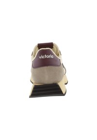 Sneaker beige e marrone con etichetta al tallone color bordeaux e suola nera, vista da dietro, con il nome del marchio "victoria" in bianco.
