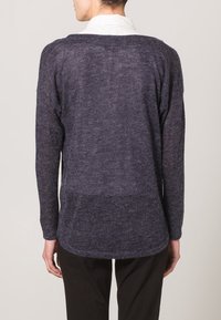 Maglione lavorato a maglia grigio scuro con maniche lunghe, una vestibilità comoda e un orlo leggermente arrotondato. La texture sembra morbida e leggera.