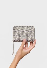 Zippered wallet in patterned grey fabric with purple wavy lines. Features a silver logo plate and a grey zipper pull for ease of use.