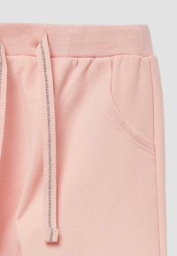 Helle rosa Jogginghose aus weichem Stoff mit elastischem Bund, ausgestattet mit einem Kordelzug und seitlichen Taschen.