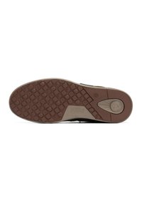 Sole in gomma marrone con motivo di presa testurizzato, presente un sottopiede beige e dettagli di marca. La scarpa ha una forma piatta e arrotondata.
