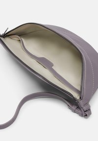 Paarse leren tas met een tan interieur, ritssluiting en een klein binnenvak. Voorzien van een slanke, afneembare strap voor het dragen.
