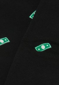 Černé ponožky s žebrovanou strukturou, na kterých jsou vyšívané malé zelené motivy dolarových bankovek rozmístěné na různých místech.