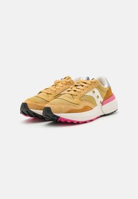 Yellow suede and leather sneakers with a white midsection, pink outsole accents, black rubber tread, and beige laces.