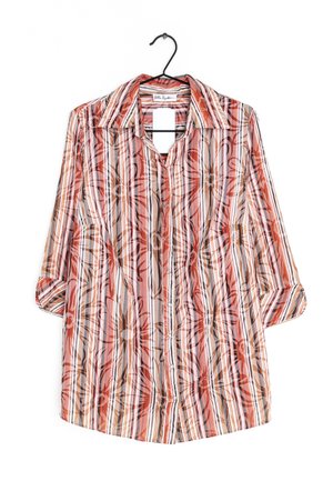 Koszula na długi rękaw z czerwonymi, pomarańczowymi i brązowymi pionowymi paskami oraz dużym kwiatowym nadrukiem, wisząca na czarnym wieszaku.