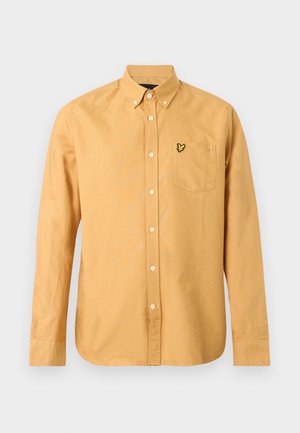 Pikkade varrukatega sinepikollane nööpidega särk, nööpidega kraega ja väikese kollase ja musta linnu tikandiga rinnataskul.