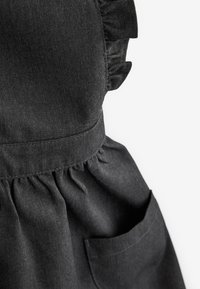 Mustmustes mustriga, millel on volangiga õladesinine disain, koondatud vöökoht ja küljetasku. Tekstuur on sile ja õrnalt läikiv.