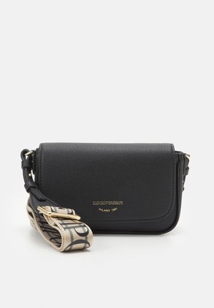 Black textured leather crossbody bag with fold-over flap and beige adjustable fabric strap featuring black pattern and gold-tone buckle.