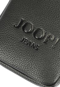 Črn usnjen denarnica z reliefnim logotipom "JOOP! JEANS", ki se ponaša s gladko površino in minimalističnim dizajnom.