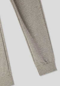 Szare joggery wykonane z miękkiego, elastycznego materiału. Posiadają elastyczne mankiety i żebrowany pas. Gładka tekstura o prostym designie.