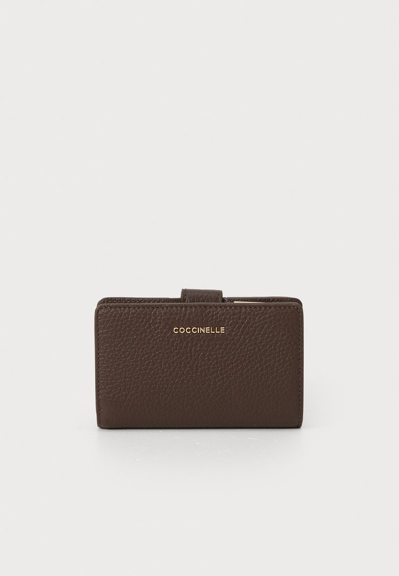 Portofel din piele maro cu o suprafață texturată, având un logo auriu pe față și o formă compactă rectangulară. Design minimalist.