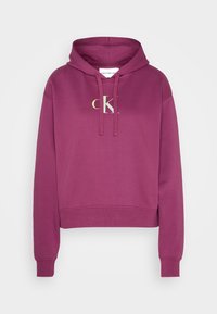 Maroon hoodie made of soft cotton, featuring a front pocket, drawstring hood, and a contrasting "CK" logo on the chest. Cropped fit.
