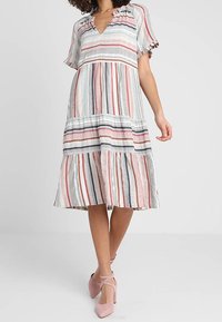 Gestreiftes Kleid mit kurzen Ärmeln, V-Ausschnitt, gestuftem Rock und roten, grauen sowie blauen Streifen auf hellem Hintergrund. Leichter Stoff.