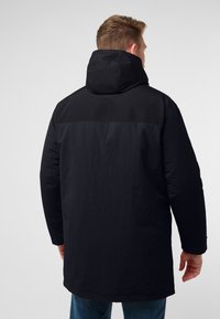Parka nera con cappuccio, caratterizzata da una texture liscia e un design bicolore sulla parte superiore della schiena. Maniche lunghe e taglio dritto.