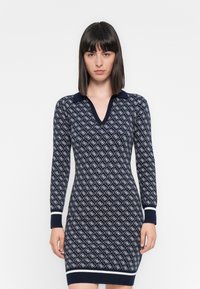 Abito in maglia con una base blu navy e un motivo a diamante bianco, scollatura a V, maniche lunghe e polsini e orlo in contrasto. Tessuto morbido.