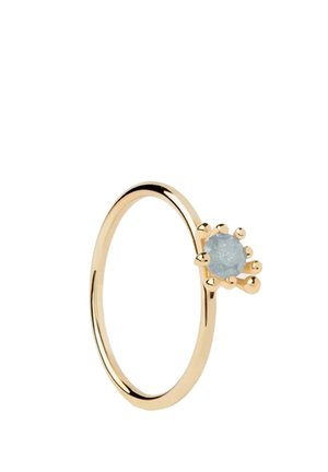 Anello d'oro con una pietra preziosa rotonda azzurro chiaro tenuta da sei griffe, mostrato su sfondo bianco.