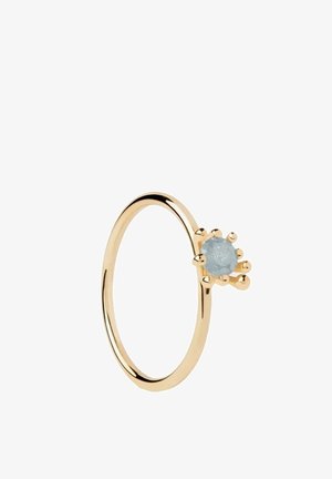 Anello d'oro con una pietra preziosa rotonda azzurro chiaro tenuta da sei griffe, mostrato su sfondo bianco.