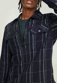 Marine geruite zip-up jas, met witte rasterlijnen, twee borstzakken met kleppen en een zachte, geweven textuur.