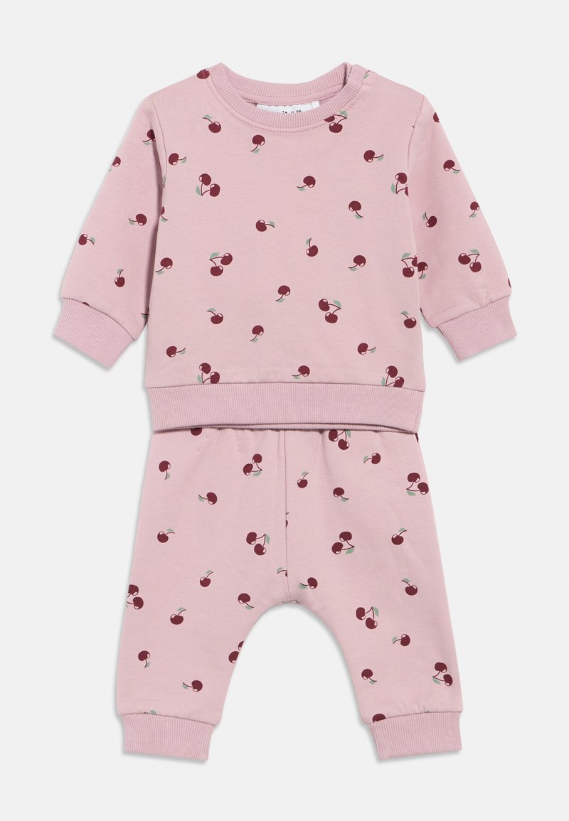 Ensemble bébé rose comprenant un haut à manches longues et un pantalon, décoré de petites imprimés de cerises rouges et de poignets côtelés aux manches et aux jambes du pantalon.