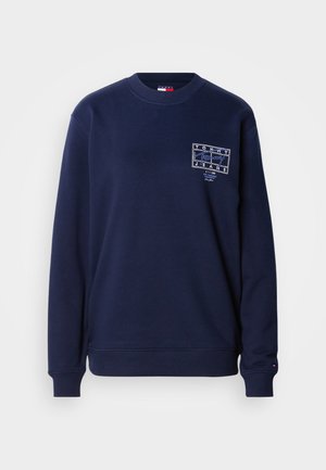 Laivastonsininen collegepaita pyöreällä pääntiellä, resorilla hihoissa ja helmassa. Edessä on valkoisella ommellun logoplaatin ja sileän puuvillamateriaalin rakenne.