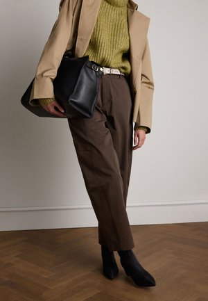 Manteau trench beige, pull côtelé vert olive, pantalon marron, sac en cuir noir, bottines noires scintillantes ; tons chauds, formes structurées.