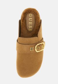 Chaussure en daim marron à enfiler, doublée de fausse fourrure, avec une boucle dorée et des motifs floraux embossés sur la sangle.