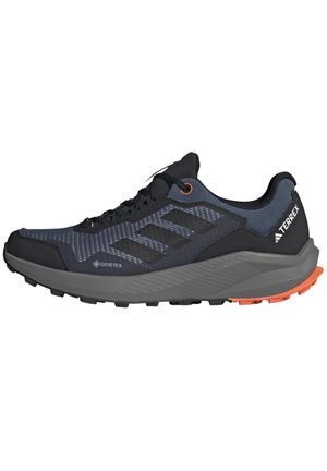 Schwarz-graue Trailrunning-Schuhe mit strukturiertem Obermaterial, GORE-TEX-Branding, orangen Akzenten und einer robusten Gummisohle für Traktion.