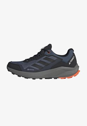 Schwarz-graue Trailrunning-Schuhe mit strukturiertem Obermaterial, GORE-TEX-Branding, orangen Akzenten und einer robusten Gummisohle für Traktion.