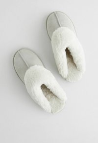 Gray suede slippers with fluffy white faux fur lining, open front design, and textured soles. Soft, cozy interior for comfort.