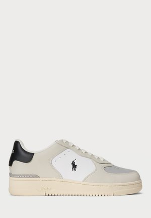 Sko med øvre del i grått og hvitt skinn, beige såle, svart hælakseent og logo på siden. Har tradisjonell snøring.