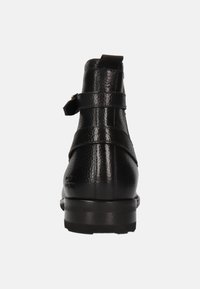 Botines negros de cuero con acabado texturizado, dos correas ajustables, punta redonda y un tacón bajo y resistente.