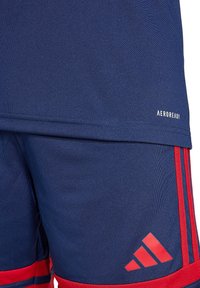 Marine sportshirt en shorts met rode accenten, gemaakt van ademende stof met AeroReady-markering aan de zoom.