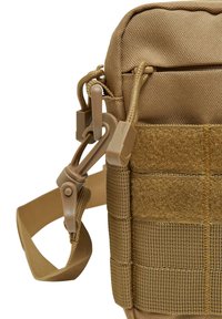 Khaki tactical shoulder bag made of durable nylon. Features a woven texture, detachable strap, and clips, with Velcro for attachment.