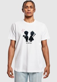 Weißes Baumwoll-T-Shirt mit einem schwarzen Silhouette-Design eines Jungen und eines Mädchens, mit Herzen darüber und dem Text "BOY MEETS GIRL" darunter.