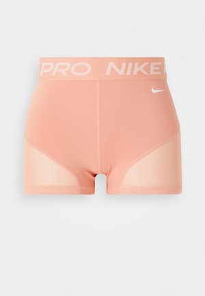 Shorts de compression pêche clair avec une large ceinture élastique portant les marques "PRO" et "NIKE", et des panneaux en maille sur les côtés pour la respirabilité.