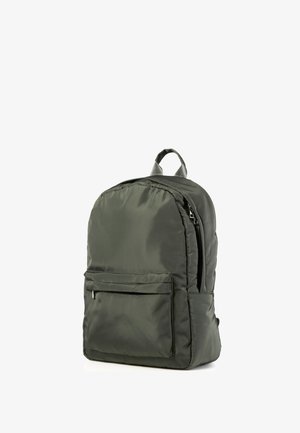 Dunkelgrüner Nylon-Rucksack mit einer vorderen Reißverschlusstasche, Hauptreißverschlussfach und einer Trageschlaufe oben, sichtbar vor weißem Hintergrund.