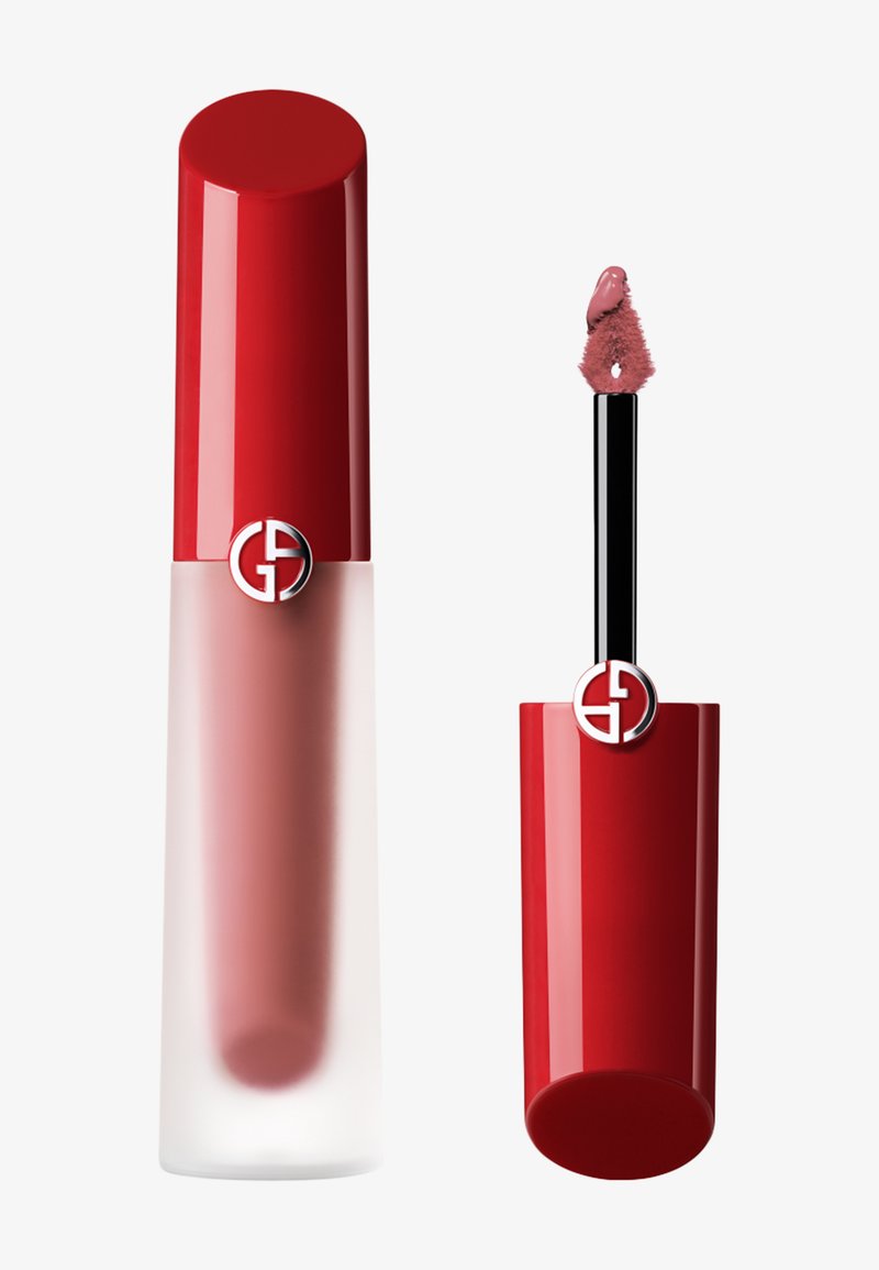 Couleur à lèvres liquide dans un tube transparent givré avec un capuchon rouge ; applicateur avec une pointe duveteuse. La couleur apparaît comme un rose doux. Logo sur le capuchon.