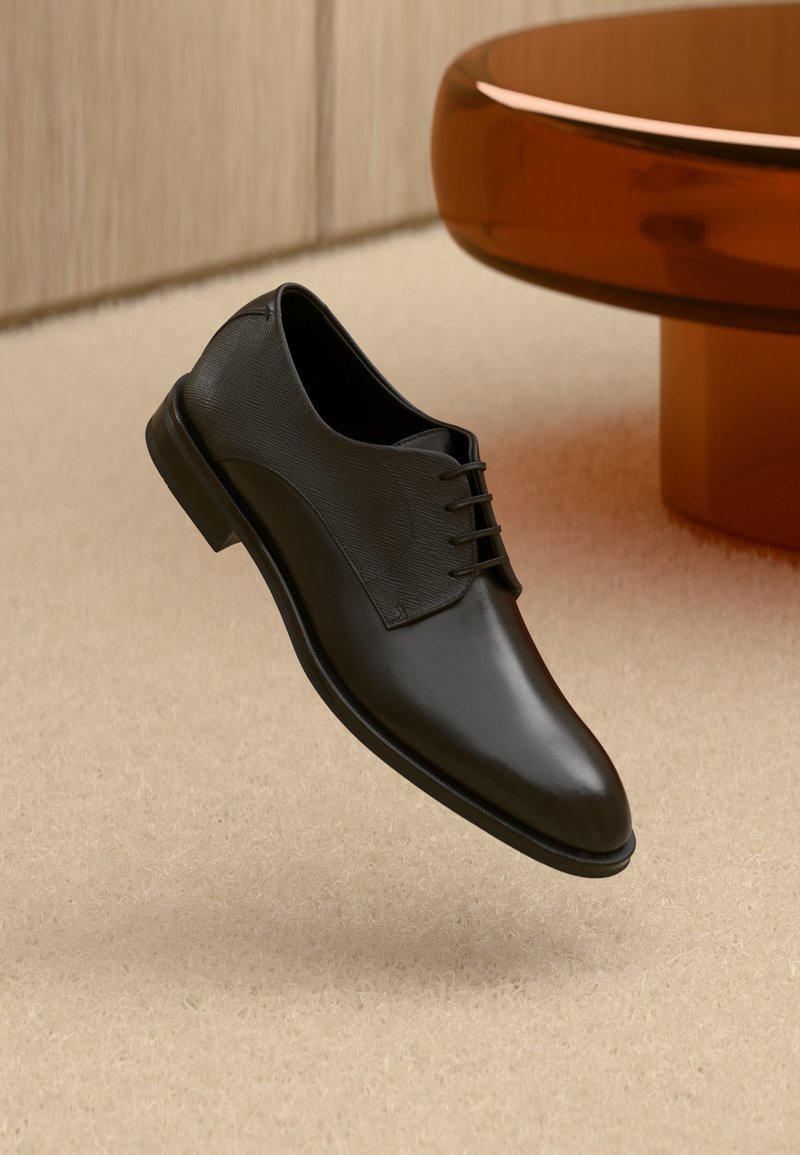 Schwarzer Lederschuh mit glattem, poliertem Finish und strukturiertem Obermaterial, ausgestattet mit sechs Ösen und einer abgerundeten Spitze.