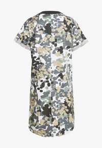 Vestido de manga corta con un patrón de camuflaje que presenta colores verde, negro y beige sobre un fondo blanco. Cuello redondo y corte relajado.