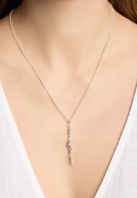 Sølv kæderegne med en vertikal vedhæng, der har varierende størrelser af klare ædelsten, der præsenterer et strømlinet og moderne design.