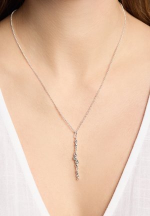 Collar de cadena de plata con un colgante vertical que presenta gemas transparentes de diferentes tamaños, exhibiendo un diseño elegante y contemporáneo.