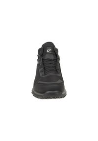 Tênis esportivos pretos com parte superior em malha, detalhes texturizados, design com atacadores e sola de borracha com aderência. Logótipo na lingueta.