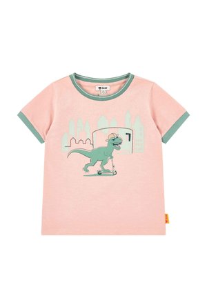 Pink toddler T-shirt with green trim, featuring a green dinosaur wearing a hat and sunglasses riding a scooter in front of a city skyline.