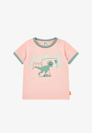 Pinker Kleinkinder-T-Shirt mit grünem Rand, darauf ein grüner Dinosaurier mit Hut und Sonnenbrille, der vor einer Stadtsilhouette einen Roller fährt.