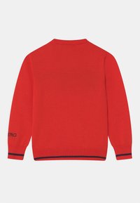Rød strikket sweater med lange ærmer, rund hals og ribbede manchetter. Sort-hvide striber ved kanten. Mærkenavn på ærmet.